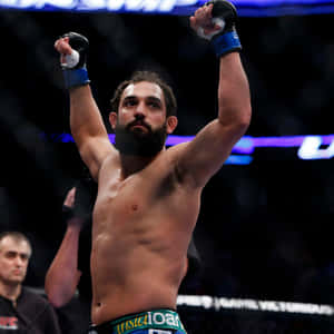 MMA拳手在八角籠中舉起拳頭慶祝勝利。