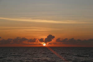 夕陽下的海洋，橙色天空與平靜水面