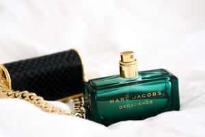 白色布料上的綠色Marc Jacobs Decadence香水瓶和黑色手拿包。