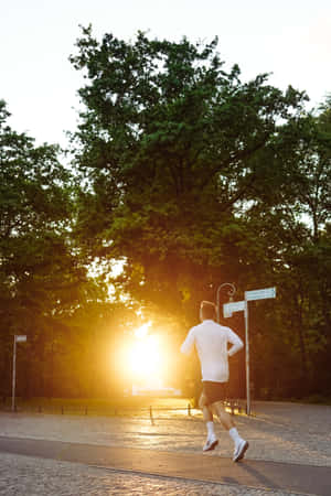 黃金時段在公園的鋪砌小徑上跑步的人。 — 跑步 壁紙