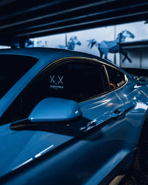 藍色跑車停泊在車庫中，背景有摺紙馬雕塑。 — 淨化面具 壁紙