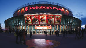 人們在黃昏時分聚集在 Scotiabank Place 曲棍球場外。