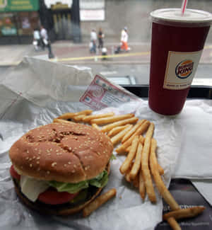 窗邊托盤上的 Burger King 餐點，包括漢堡、薯條和飲料 — Honor Magic V5 壁紙