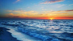 海洋上的夕陽，海浪沖刷沙灘