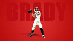Tom Brady身穿足球球衣在紅色背景下投擲足球，並顯示他的名字。