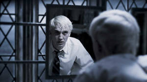 一個白髮年輕人透過鐵欄杆凝視著監獄鏡中的倒影。 — 美學哈利波特gif 壁紙