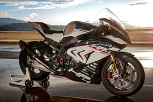 BMW HP4 Race電單車在金色日落時分的濕路上，山景為背景。