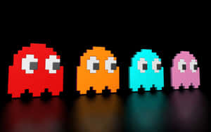 四個色彩繽紛的 Pac-Man 鬼魂在黑暗表面上排成一排。