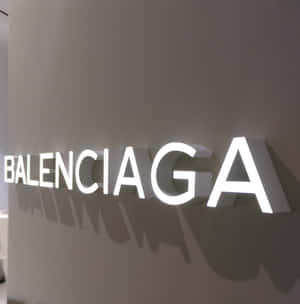 灰色牆壁上發光的 Balenciaga 標誌投下陰影。