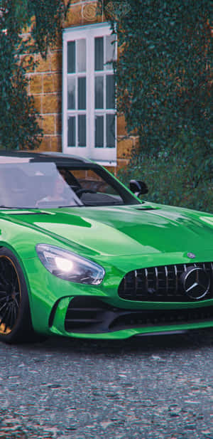 充滿活力的綠色 Mercedes-AMG GT 停在爬滿常春藤的石頭建築旁。 — Huawei Mate 70 Air 壁紙