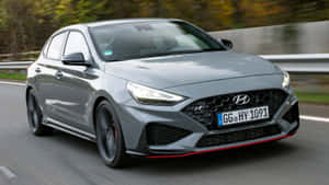 灰色現代 i30 N 跑車在秋葉中飛馳。