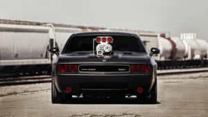 黑色Dodge Challenger SRT配備增壓器，停泊在火車軌道附近。