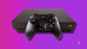黑色Xbox主機和手掣在紫色粉紅色漸變背景上。