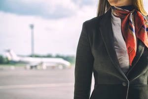 在機場停機坪上戴著彩色圍巾的空中服務員。
