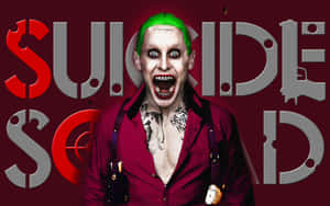 帶有綠色頭髮和紋身的小丑角色在深紅色背景上尖叫，並帶有「Suicide Squad」文字。