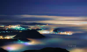充滿霧氣和閃爍城市燈光的山谷夜景。