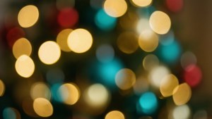 柔和模糊的聖誕燈飾，散發溫暖的金色、藍綠色和紅色色調。