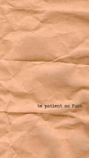 皺巴巴的米色紙張，上面有「be patient as fuck」這句短語以黑色印刷。 — 明亮 壁紙