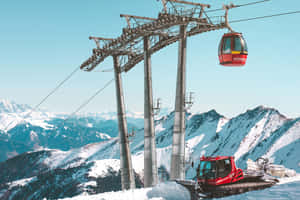晴朗藍天下，白雪覆蓋的山坡上的紅色纜車和雪地車。