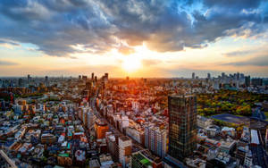 夕陽映照在密集的城市，高樓大廈林立，金色光芒穿透雲層。