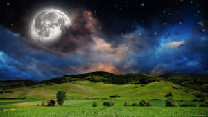 在明亮的月亮和繁星點點的夜空下，起伏的綠色山丘。