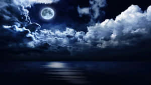 滿月穿過雲層照耀在夜晚平靜的海洋上。 — 暮光 壁紙