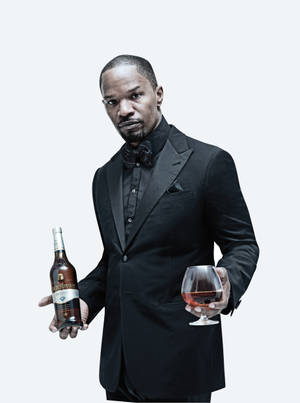 穿黑色燕尾服的男人拿著威士忌酒瓶和酒杯。