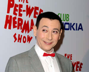 Paul Reubens 身穿灰色西裝和紅色領結，出席 Pee-wee Herman 活動。 — 卡爾文與霍布斯 壁紙