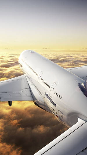 漢莎航空飛機在日出時飛越金色雲層。 — 雲朵 壁紙