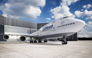 漢莎航空波音747在陽光普照、有雲的天空下停在機場停機坪。