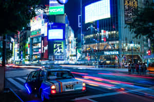 夜晚霓虹燈照亮嘅東京街道，有模糊嘅車燈同行人。