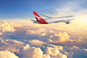 澳洲航空飛機在日落時飛越金色雲層。