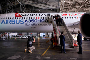Qantas Airbus A350-100 飛機在機庫內，人們登機，攝影師捕捉場景。