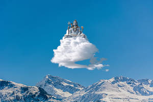 銀色神像在藍天下白雪覆蓋的山脈上方的雲端冥想