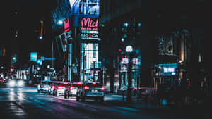 夜晚的城市街道，霓虹招牌和濕漉漉的路面反射燈光。 — 黑暗森林 壁紙