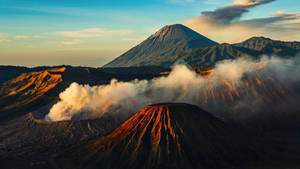 日出時蒸氣升起的火山山脈