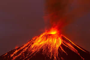 火山爆發，明亮的熔岩在夜間沿著側面流下。 — MacBook Pro 壁紙