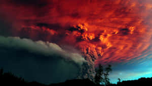火山爆發，熾熱的火山灰映襯著暮色天空和樹木剪影。 — 湖景 壁紙
