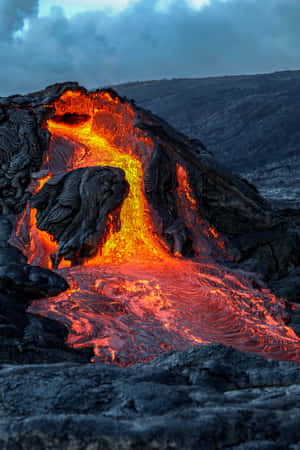夜間熔岩流沿著黑暗的火山懸崖發出橙色光芒。 — Huawei MatePad 11.5 (2025) 壁紙