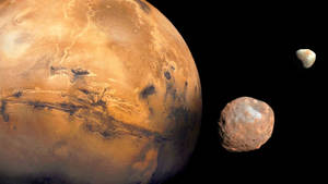 火星與兩顆小行星漂浮在太空的黑暗中。