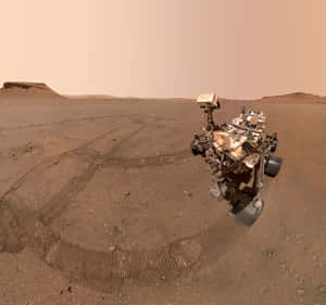 火星探測車在紅色沙丘上留下痕跡，橙色天空