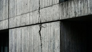 破裂混凝土建築牆壁的特寫，可見紋理和陰影