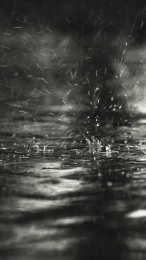 雨滴在黑暗的水面上飛濺散開的單色畫面。 — 雨 壁紙