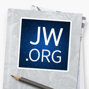 JW.ORG貼紙在灰色筆記本上，旁邊有鉛筆