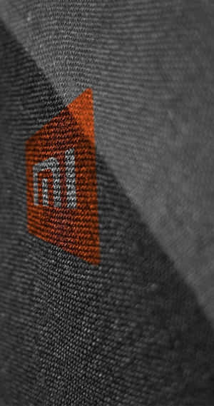 灰色布料紋理上的刺繡Xiaomi標誌 — Xiaomi 壁紙