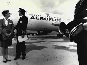 身穿制服的航空公司機組人員在停機坪上Aeroflot飛機旁迎接乘客。
