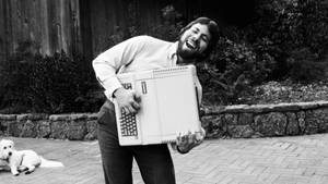 男人攞住Apple II電腦同狗喺花園笑 — 黑白 壁紙