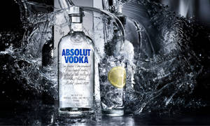 飛濺水花中的Absolut Vodka酒瓶和酒杯，附有檸檬。