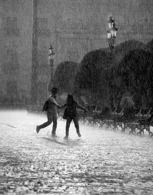 兩個人在暴雨中一起在廣場上奔跑。 — 情侶 GIF 壁紙