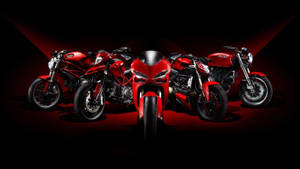 四輛紅色Ducati電單車在黑暗工作室中於聚光燈下展示。